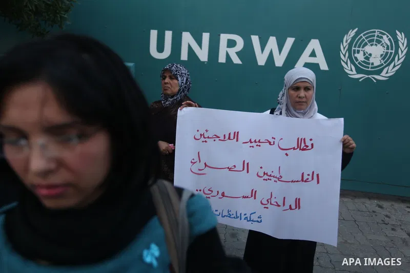 Palestinians hold placards during a protest in solidarity with Palestinian in al-Yarmouk refugee camp in Syria in In front of the United Nations headquarters in Gaza City on 18 December 2012. Pro-rebel sources reported t...