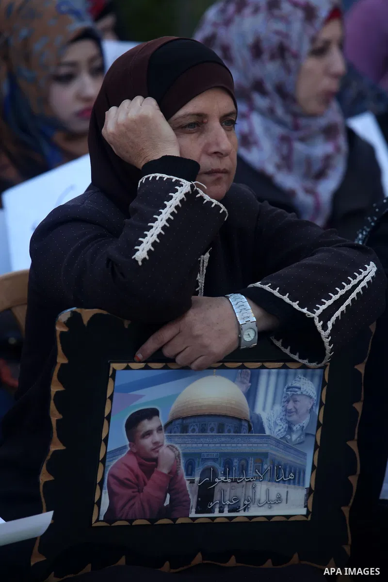 Palestinians hold pictures of prisoners held in Israeli jails during a sit-in outside the Red Crescent offices near the West Bank city of Ramallah on December 17, 2012. in solidarity with hunger-striking detainees held b...