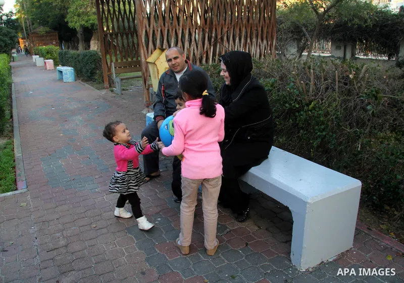 A Palestinian woman, Samar Bulbul plays with her kids at a park in Gaza city on Dec. 18,2012. Bulbul lost hearing after an Israeli airstrike targeted two Palestinian militants' car in Gaza city in December 2011. Photo by...
