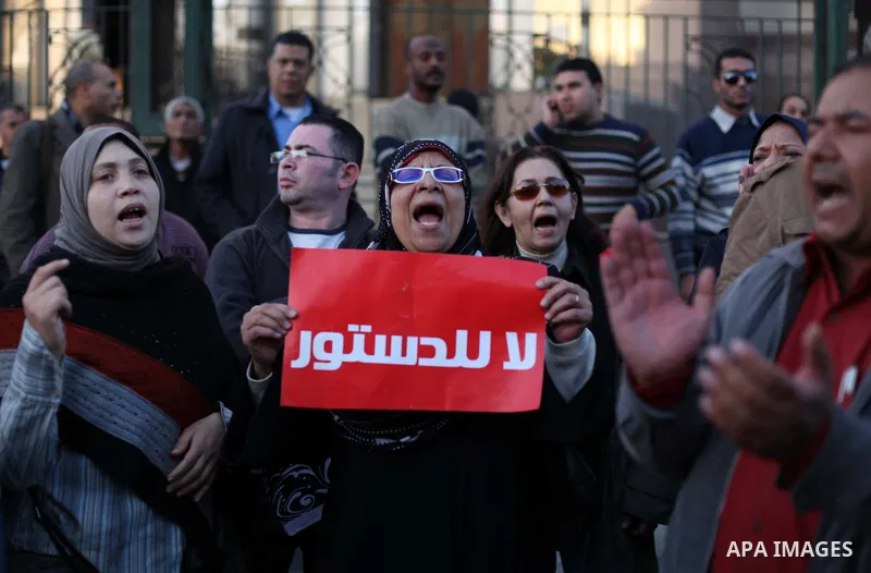Egyptian protesters shout slogans against the President Mohamed Morsi and hold a banner reading in Arabic 'no to the constitution' during a demonstration against the draft constitution, in Cairo, Egypt, 18 December 2012....