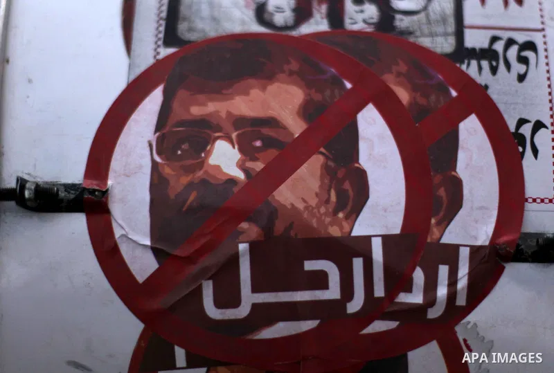 A portrait is seen for Egyptian President Mohamed Morsi with a word reading in Arabic 'leave' during a demonstration against the draft constitution, in Cairo, Egypt, 18 December 2012. The Egyptian opposition called for d...