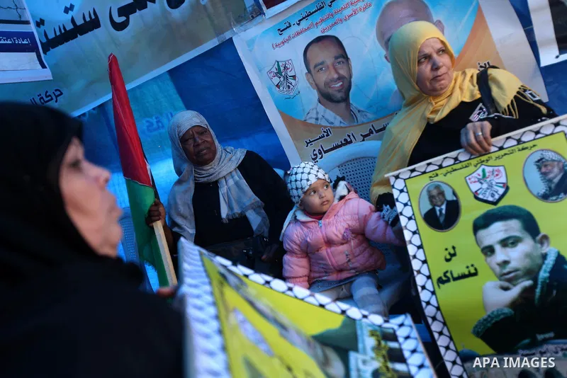 Palestinians hold pictures of prisoners held in the Israeli jails during a rally in Gaza city on December 19, 2012. in solidarity with hunger-striking detainees held by Israel to demand their release from detention witho...