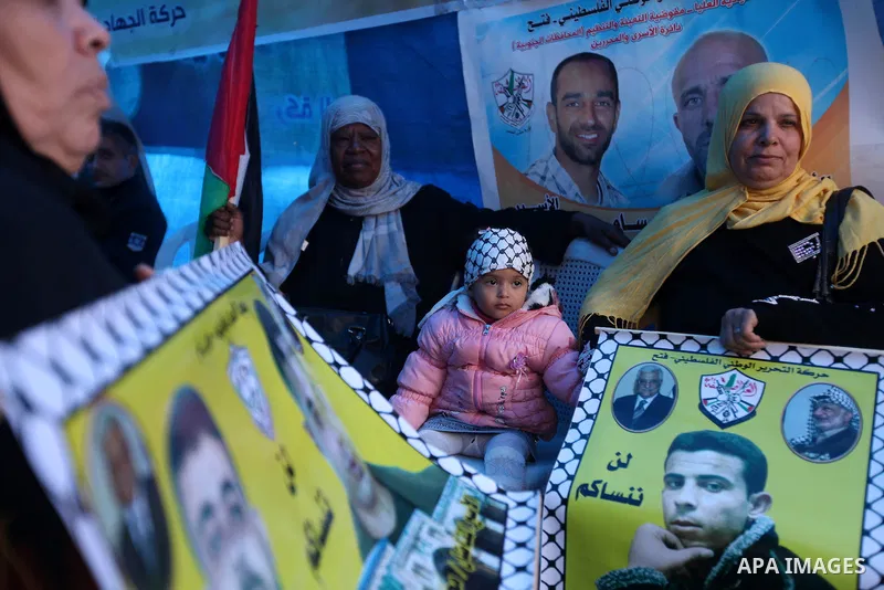 Palestinians hold pictures of prisoners held in the Israeli jails during a rally in Gaza city on December 19, 2012. in solidarity with hunger-striking detainees held by Israel to demand their release from detention witho...