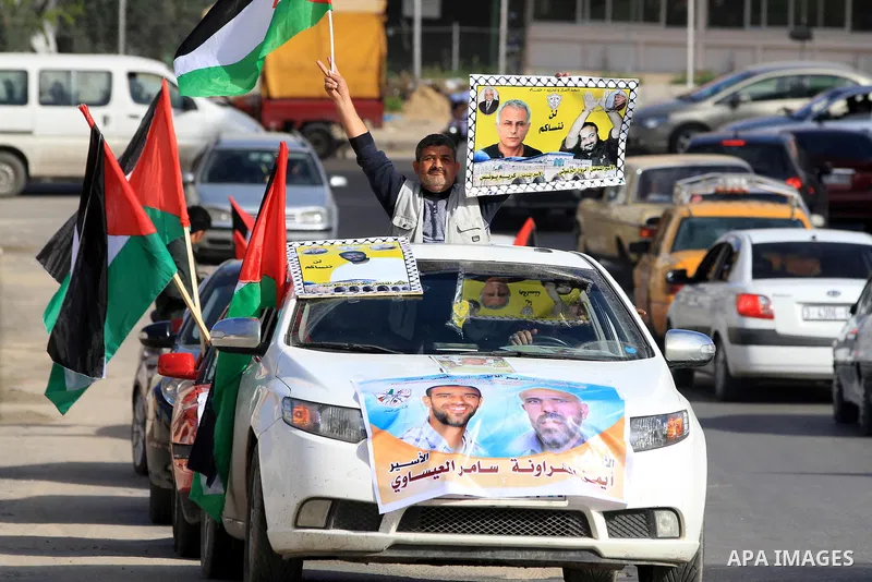 Palestinians hold pictures of prisoners held in the Israeli jails during a rally in Gaza city on December 19, 2012. in solidarity with hunger-striking detainees held by Israel to demand their release from detention witho...