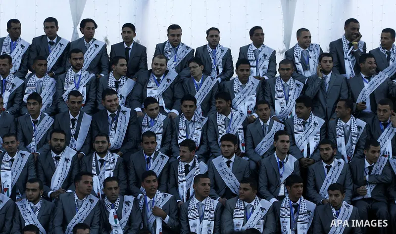 Palestinians grooms pose during a mass wedding ceremony in Rafah southern Gaza strip, on December 19, 2012. The mass wedding organized by National Islamic Committee and funding by the institution of Sheikh Khalifa bin Za...