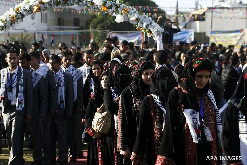 Palestinian brides and grooms pose during a mass wedding ceremony in Rafah southern Gaza strip, on December 19, 2012. The mass wedding organized by National Islamic Committee and funding by the institution of Sheikh Khal...