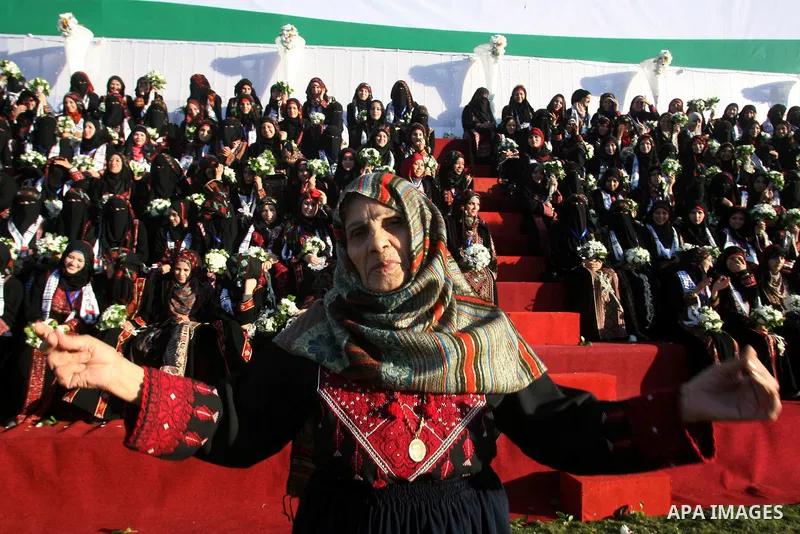 A Palestinian woman performs traditional dance during a mass wedding ceremony in Rafah southern Gaza strip, on December 19, 2012. The mass wedding organized by National Islamic Committee and funding by the institution of...