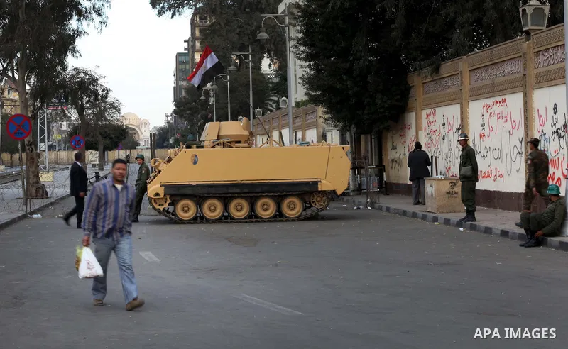 Egyptian army soldiers and tanks stand behind barbed wire as hundreds of opposition protesters arrive at the Presidential Palace in Cairo on December 19, 2012 during a demonstration against President Mohammed Morsi and t...