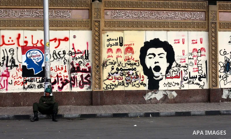 A member of of Egypt's Republican Guard sit a barbed wire barricade as they guard the presidental palace in Cairo December 19, 2012. Opponents of Egyptian President Mohamed Mursi staged protests in Cairo on Tuesday again...