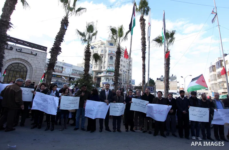 Palestinians hold placards during a protest in solidarity with Palestinian in al-Yarmouk refugee camp in Syria in the West Bank city of Ramallah on 19 December 2012. Pro-rebel sources reported that at least 25 Palestinia...