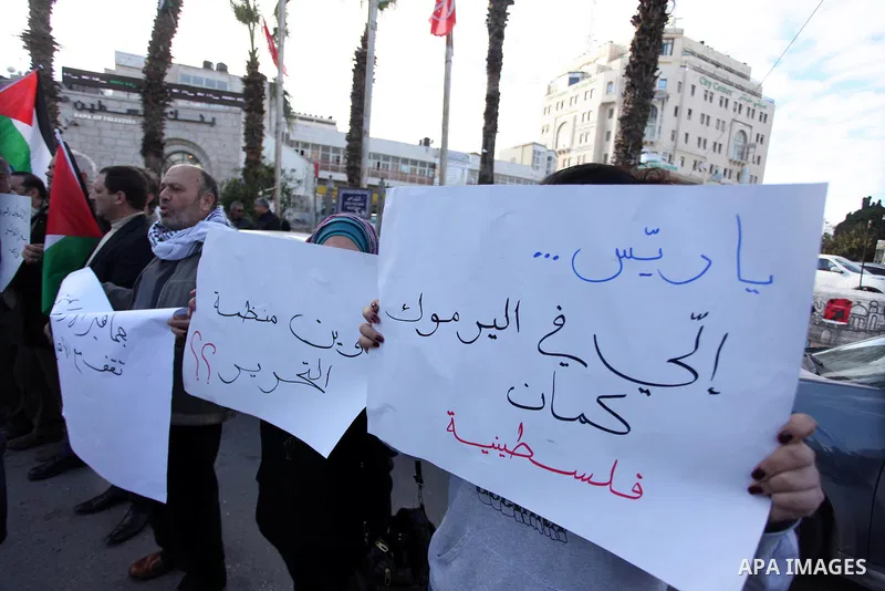 Palestinians hold placards during a protest in solidarity with Palestinian in al-Yarmouk refugee camp in Syria in the West Bank city of Ramallah on 19 December 2012. Pro-rebel sources reported that at least 25 Palestinia...