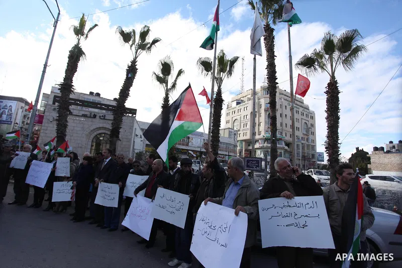 Palestinians hold placards during a protest in solidarity with Palestinian in al-Yarmouk refugee camp in Syria in the West Bank city of Ramallah on 19 December 2012. Pro-rebel sources reported that at least 25 Palestinia...