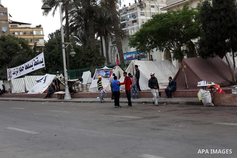 Egyptians opposition supporter stand at the presidential palace and anti-Morsi graffiti is seen on the palace's wall behind him in Cairo, Dec. 18, 2012. Egypt's opposition staged rallies across the country on Tuesday to...