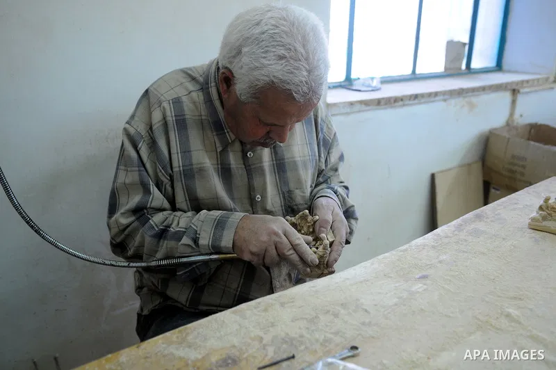 A Palestinian carpenter carves a wooden sculpture of baby Jesus at a workshop in the West Bank town of Bethlehem, on December 20, 2012. The traditional birthplace of Jesus Christ prepares to celebrate Christmas later thi...