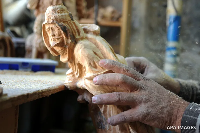 A Palestinian carpenter carves a wooden sculpture of baby Jesus at a workshop in the West Bank town of Bethlehem, on December 20, 2012. The traditional birthplace of Jesus Christ prepares to celebrate Christmas later thi...