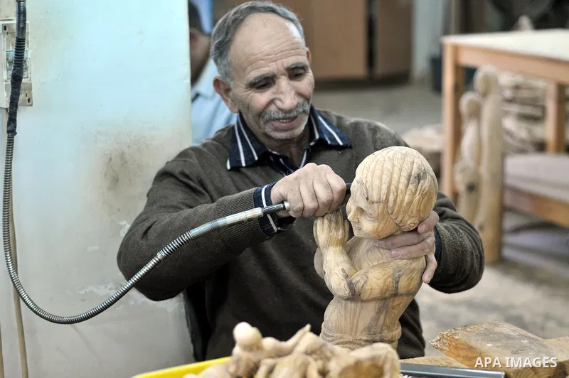 A Palestinian carpenter carves a wooden sculpture of baby Jesus at a workshop in the West Bank town of Bethlehem, on December 20, 2012. The traditional birthplace of Jesus Christ prepares to celebrate Christmas later thi...