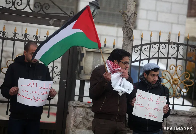 Palestinian protesters hold posters and a sign reading "ICRC, do your work or leave" during a demonstration in support of Palestinian prisoners held in Israeli jails, some of whom are observing a hunger strike, outside t...