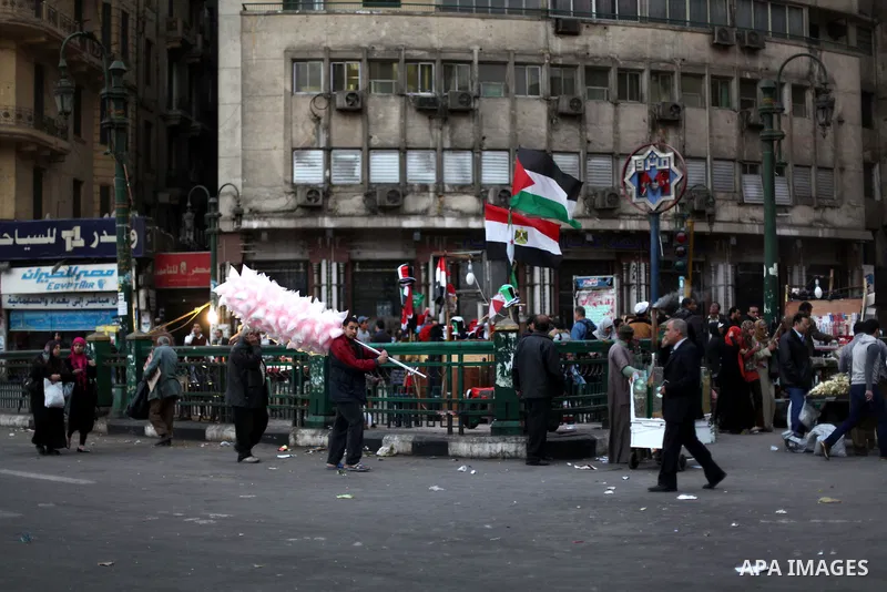 People walk past a stall displaying Egyptian flags for sale at Tahrir Square where protesters opposing President Mohamed Mursi are camping in Cairo December 20, 2012. Egyptian Islamist groups are planning a mass protest...