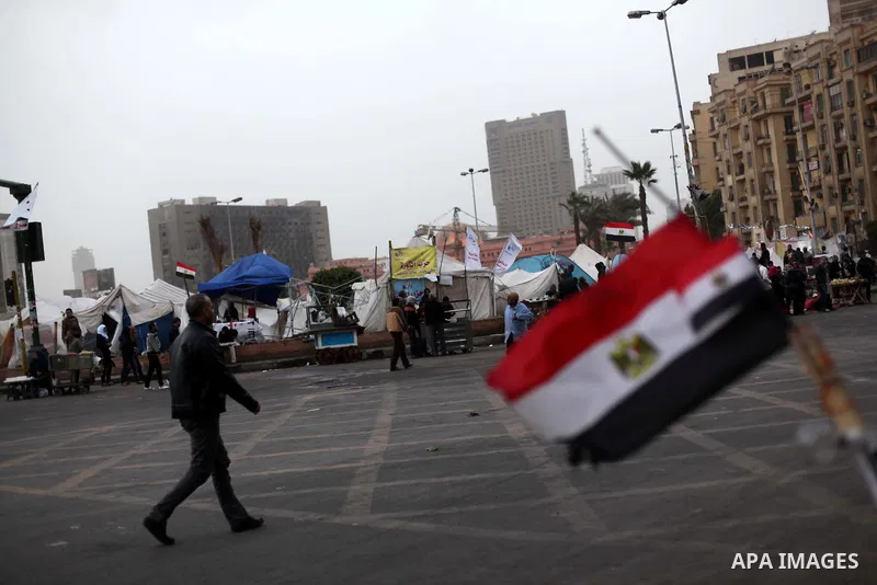 People walk past a stall displaying Egyptian flags for sale at Tahrir Square where protesters opposing President Mohamed Mursi are camping in Cairo December 20, 2012. Egyptian Islamist groups are planning a mass protest...