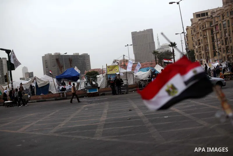People walk past a stall displaying Egyptian flags for sale at Tahrir Square where protesters opposing President Mohamed Mursi are camping in Cairo December 20, 2012. Egyptian Islamist groups are planning a mass protest...