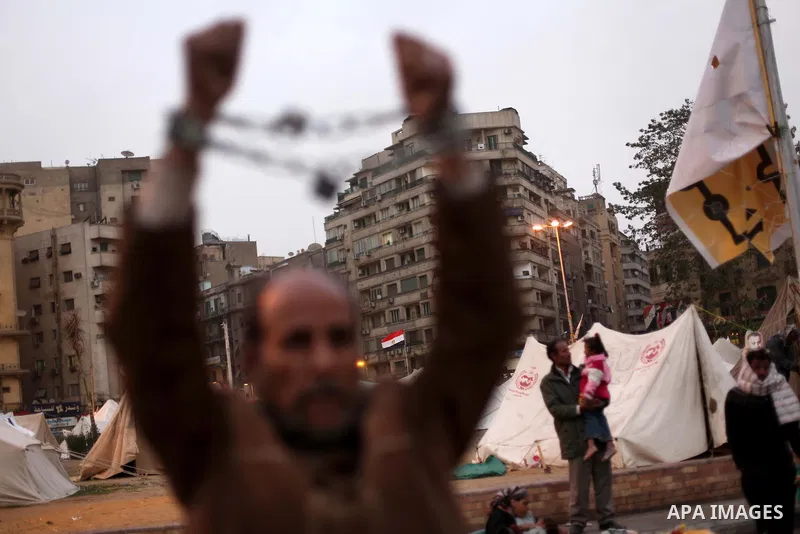 An Egyptian protester with chains around his wrists stands at Tahrir Square where protesters opposing President Mohamed Mursi are camping in Cairo December 20, 2012. Egyptian Islamist groups are planning a mass protest i...
