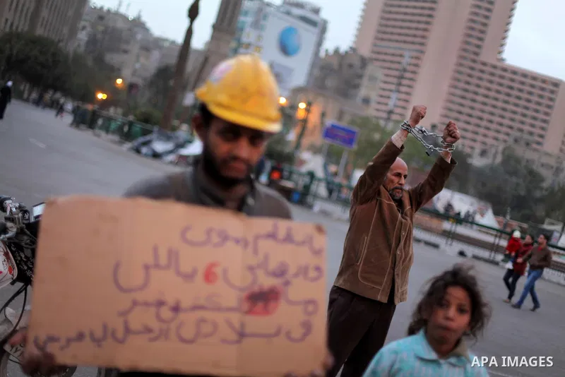 An Egyptian protester with chains around his wrists stands at Tahrir Square where protesters opposing President Mohamed Mursi are camping in Cairo December 20, 2012. Egyptian Islamist groups are planning a mass protest i...
