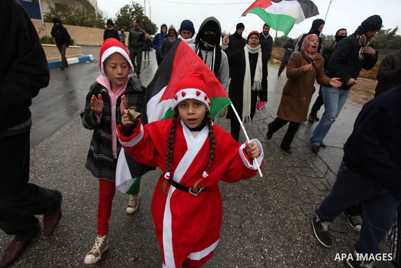 Palestinian protesters hold national flah during a weekly protest against the Jewish settlement of Halamish in the West Bank village of Nabi Saleh, near Ramallah December 21, 2012. Photo by Issam Rimawi