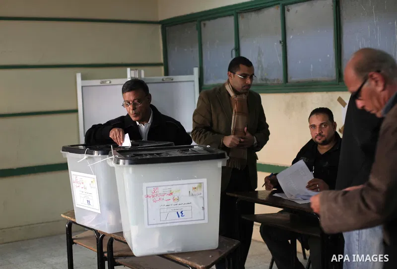 An Egyptian man casts her ballot at a polling station during the second round of a referendum on a new draft constitution in Giza, south of Cairo, on December 22, 2012. Egyptians are voting in the final round of a refere...