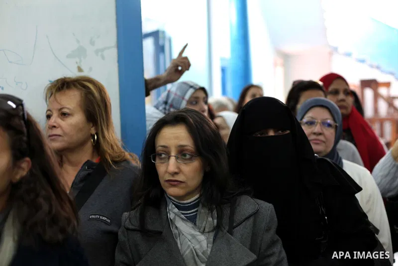 Egyptian women queue with other voters at a polling station during the second round of a referendum on a new draft constitution in Giza, south of Cairo, on December 22, 2012. Egyptians are voting in the final round of a...