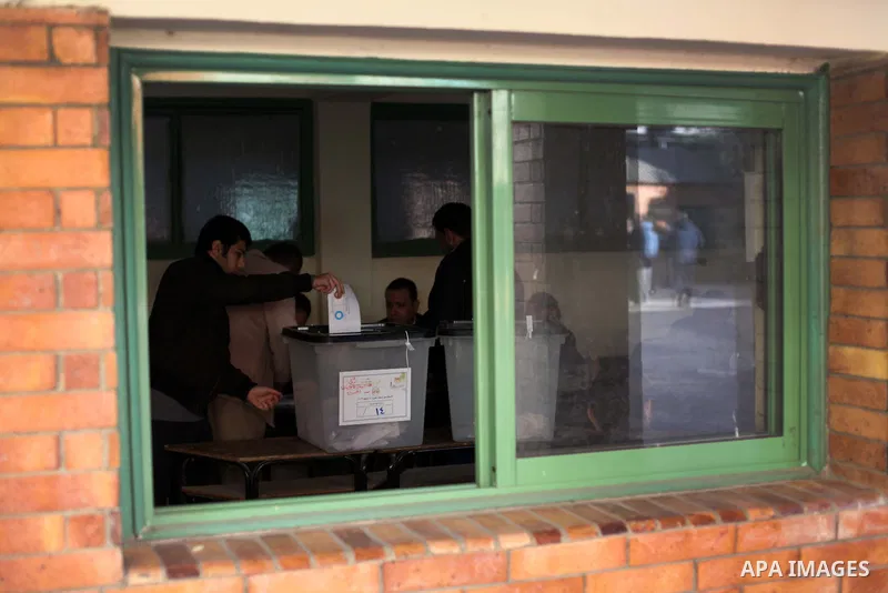 An Egyptian man casts her ballot at a polling station during the second round of a referendum on a new draft constitution in Giza, south of Cairo, on December 22, 2012. Egyptians are voting in the final round of a refere...