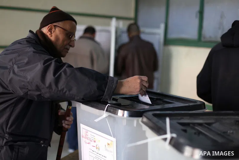 An Egyptian man casts her ballot at a polling station during the second round of a referendum on a new draft constitution in Giza, south of Cairo, on December 22, 2012. Egyptians are voting in the final round of a refere...