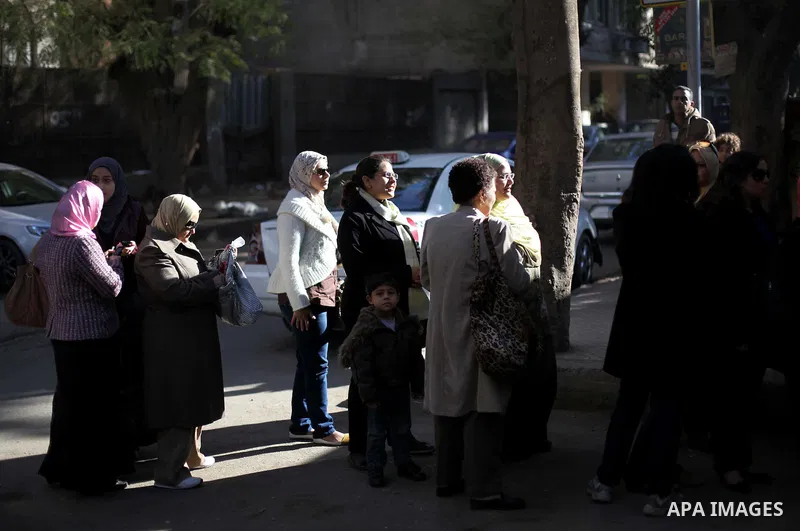 Egyptian women queue with other voters at a polling station during the second round of a referendum on a new draft constitution in Giza, south of Cairo, on December 22, 2012. Egyptians are voting in the final round of a...