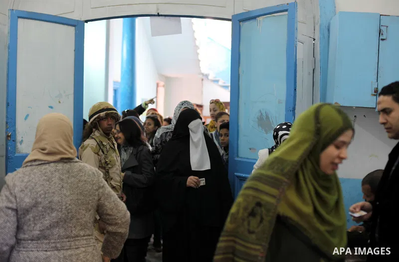 Egyptian women queue with other voters at a polling station during the second round of a referendum on a new draft constitution in Giza, south of Cairo, on December 22, 2012. Egyptians are voting in the final round of a...