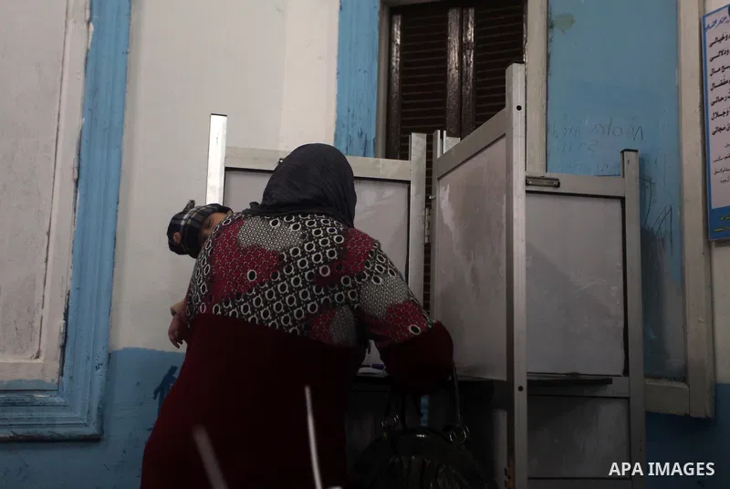 An Egyptian woman casts her ballot at a polling station during the second round of a referendum on a new draft constitution in Giza, south of Cairo, on December 22, 2012. Egyptians are voting in the final round of a refe...