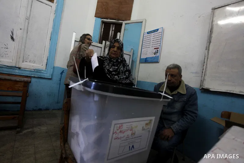 An Egyptian woman casts her ballot at a polling station during the second round of a referendum on a new draft constitution in Giza, south of Cairo, on December 22, 2012. Egyptians are voting in the final round of a refe...