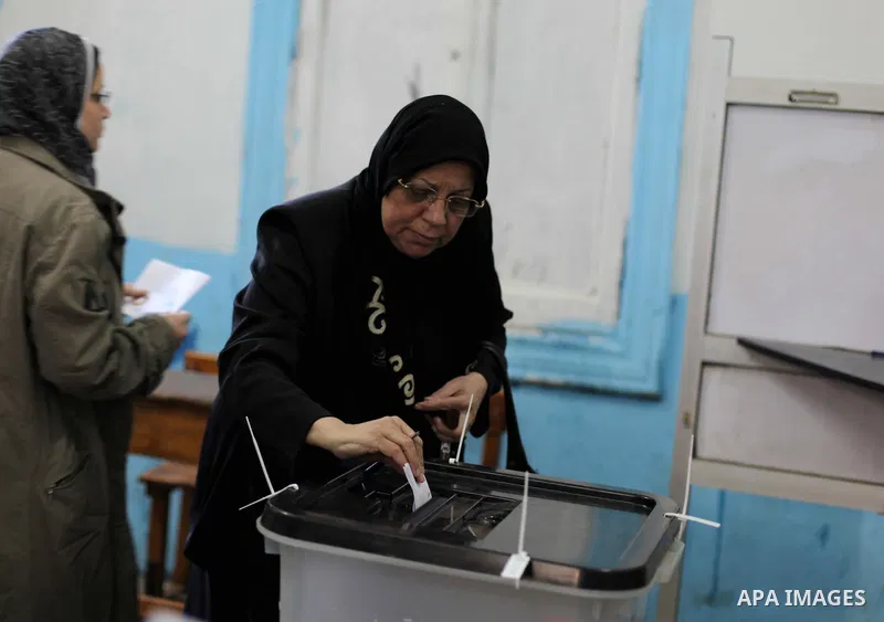 An Egyptian woman casts her ballot at a polling station during the second round of a referendum on a new draft constitution in Giza, south of Cairo, on December 22, 2012. Egyptians are voting in the final round of a refe...