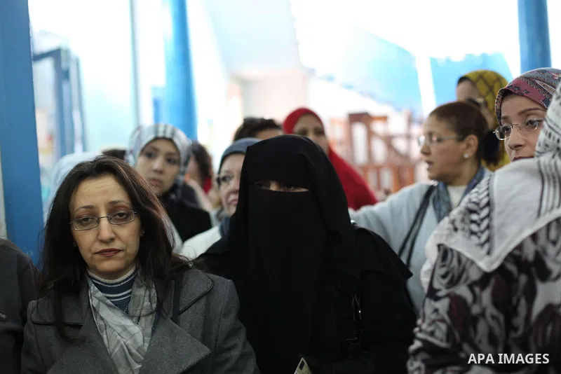 Egyptian women queue with other voters at a polling station during the second round of a referendum on a new draft constitution in Giza, south of Cairo, on December 22, 2012. Egyptians are voting in the final round of a...