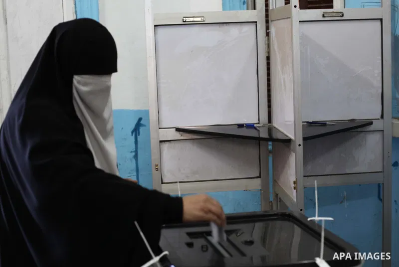 An Egyptian woman casts her ballot at a polling station during the second round of a referendum on a new draft constitution in Giza, south of Cairo, on December 22, 2012. Egyptians are voting in the final round of a refe...