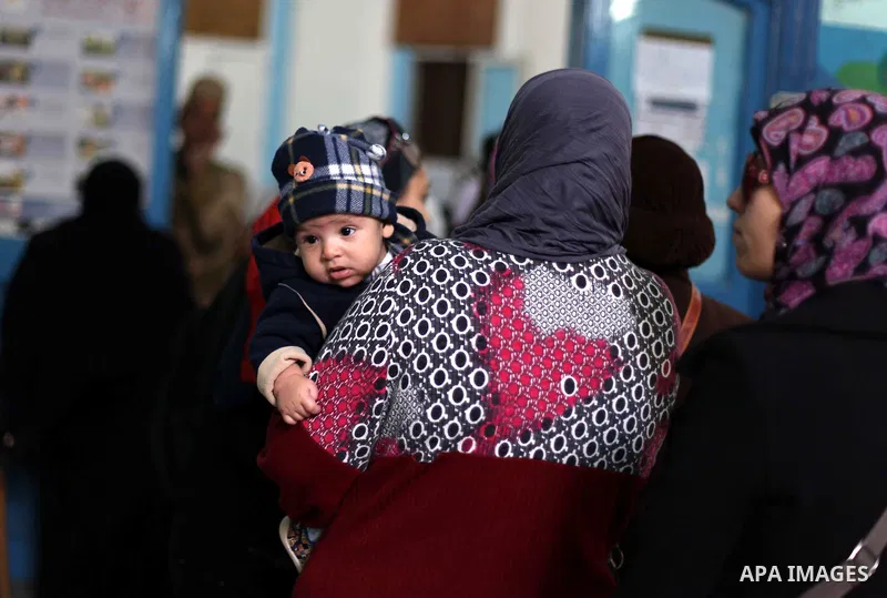 Egyptian women queue with other voters at a polling station during the second round of a referendum on a new draft constitution in Giza, south of Cairo, on December 22, 2012. Egyptians are voting in the final round of a...