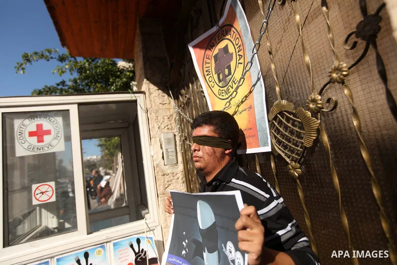 A Palestinian man who covered their eyes with black ribbons demonstrate in support of Palestinian prisoners held in Israeli jails, some of whom are observing a hunger strike, in Gaza City on December 22, 2012. Photo by M...