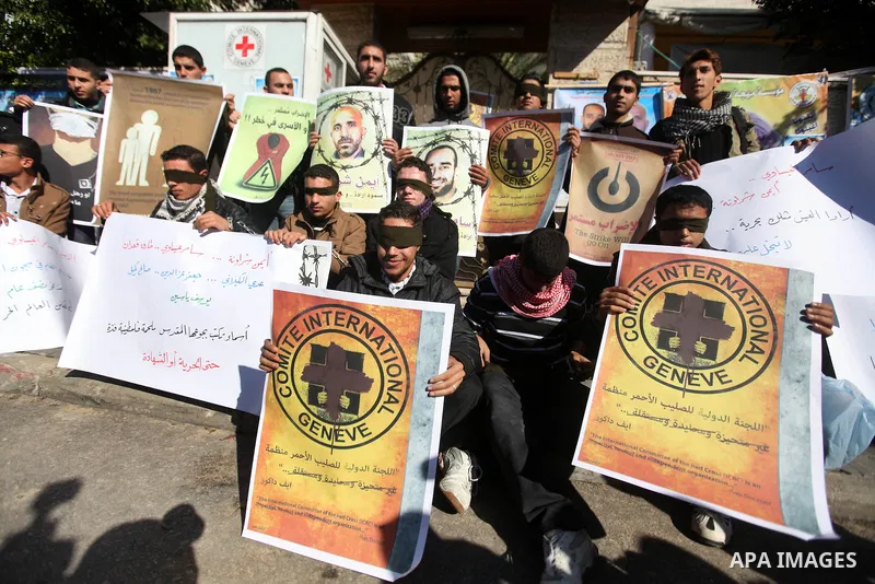 Palestinians who covered their eyes with black ribbons demonstrate in support of Palestinian prisoners held in Israeli jails, some of whom are observing a hunger strike, in Gaza City on December 22, 2012. Photo by Majdi...