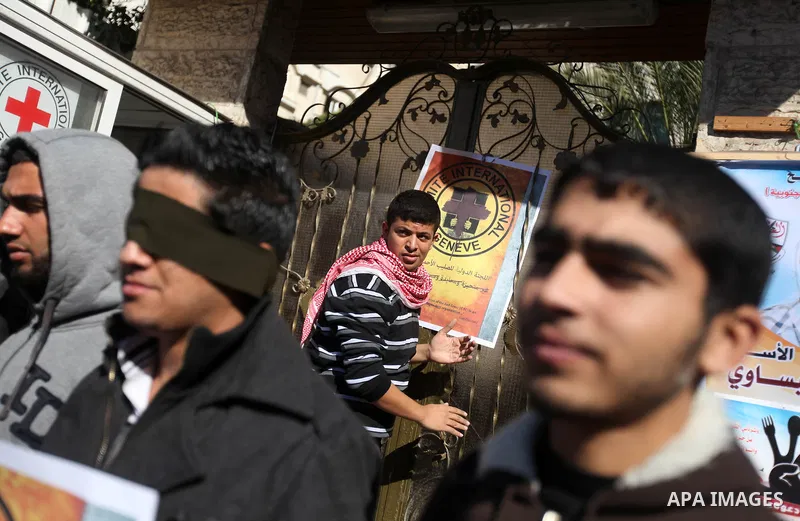 A Palestinian man lays posters demonstrate in support of Palestinian prisoners held in Israeli jails, some of whom are observing a hunger strike, in Gaza City on December 22, 2012. Photo by Majdi Fathi