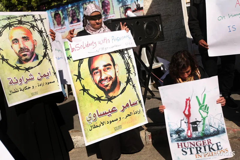 Palestinians who covered their eyes with black ribbons demonstrate in support of Palestinian prisoners held in Israeli jails, some of whom are observing a hunger strike, in Gaza City on December 22, 2012. Photo by Majdi...