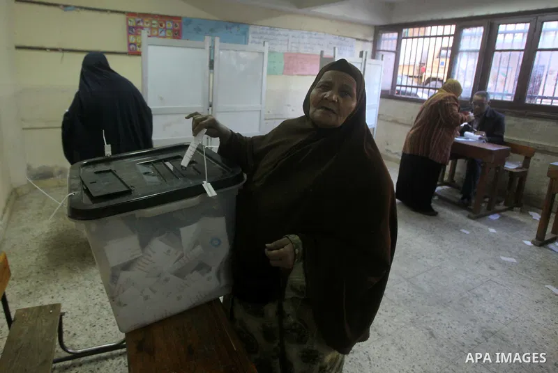 An Egyptian woman casts her ballot at a polling station during the second round of a referendum on a new draft constitution in Giza, south of Cairo, on December 22, 2012. Egyptians are voting in the final round of a refe...