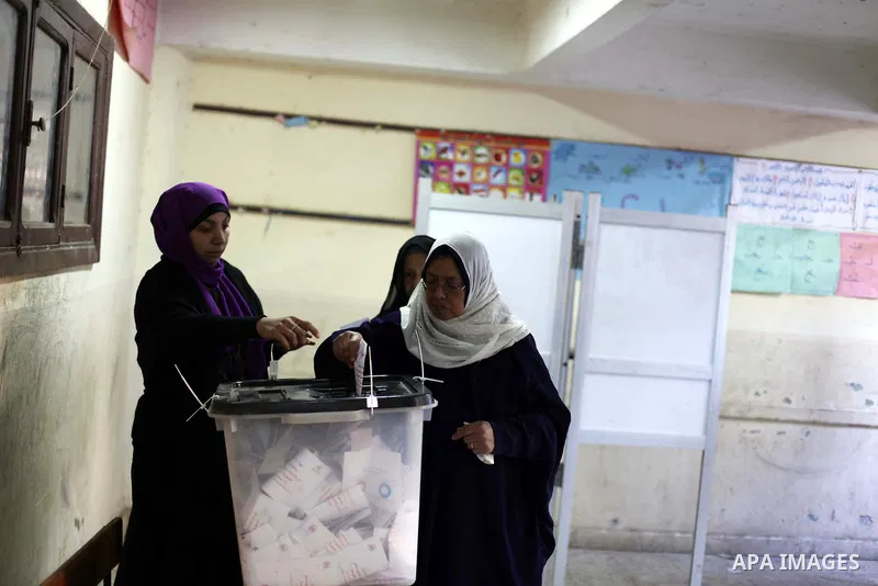 An Egyptian woman casts her ballot at a polling station during the second round of a referendum on a new draft constitution in Giza, south of Cairo, on December 22, 2012. Egyptians are voting in the final round of a refe...