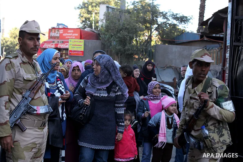 Egyptian women queue with other voters at a polling station during the second round of a referendum on a new draft constitution in Giza, south of Cairo, on December 22, 2012. Egyptians are voting in the final round of a...