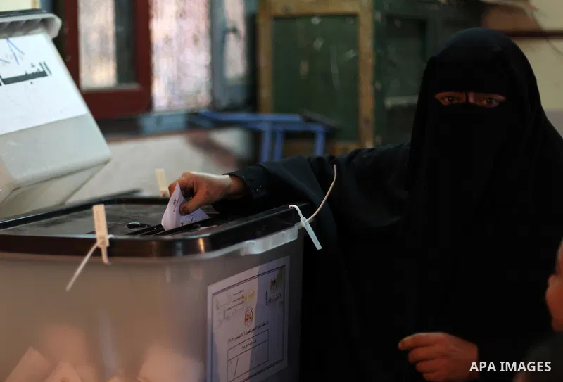 An Egyptian woman casts her ballot at a polling station during the second round of a referendum on a new draft constitution in Giza, south of Cairo, on December 22, 2012. Egyptians are voting in the final round of a refe...