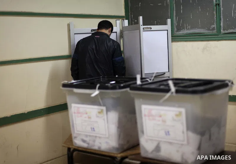 An Egyptian man casts her ballot at a polling station during the second round of a referendum on a new draft constitution in Giza, south of Cairo, on December 22, 2012. Egyptians are voting in the final round of a refere...