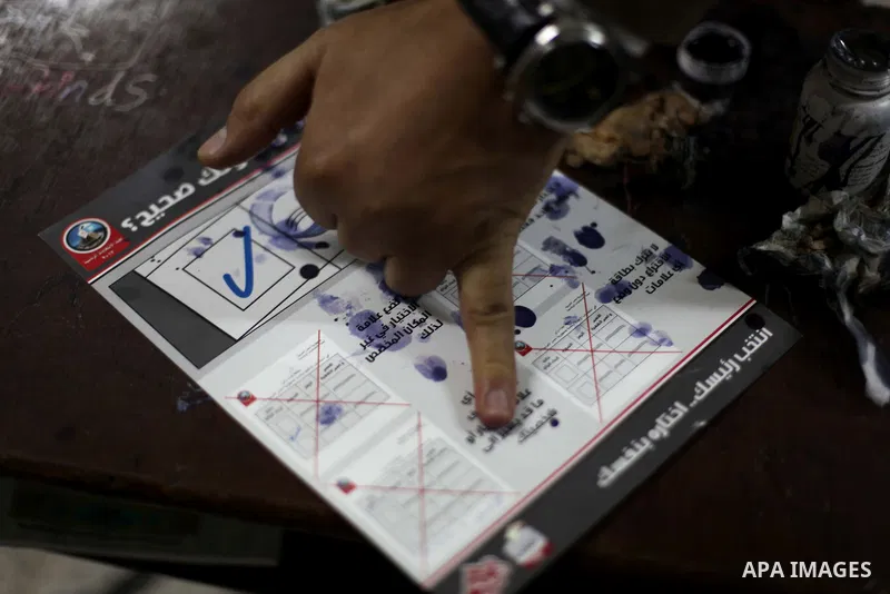 An Egyptian man dips her finger in ink after voting in the second round of a referendum on a new draft constitution in Giza, south of Cairo, on December 22, 2012. Egyptians are voting in the final round of a referendum o...