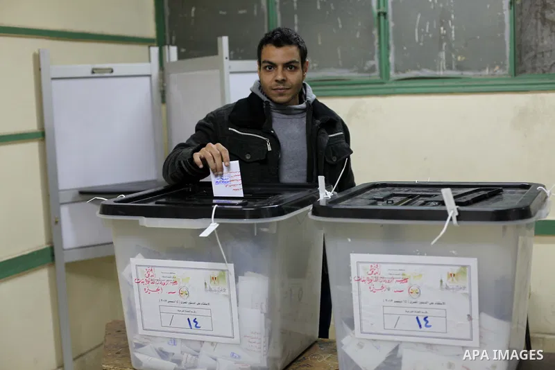 An Egyptian man casts her ballot at a polling station during the second round of a referendum on a new draft constitution in Giza, south of Cairo, on December 22, 2012. Egyptians are voting in the final round of a refere...